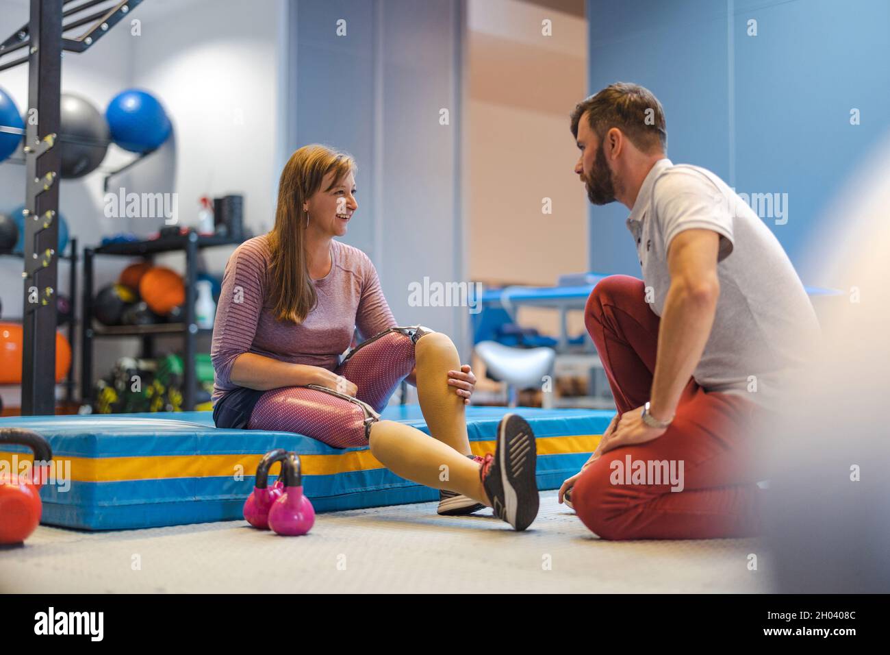 Physiotherapist helping young woman with prosthetic legs Stock Photo