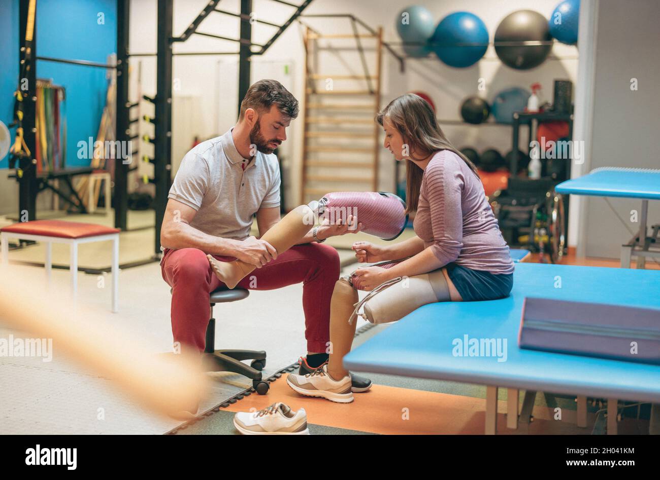 Physiotherapist helping young woman with prosthetic legs Stock Photo