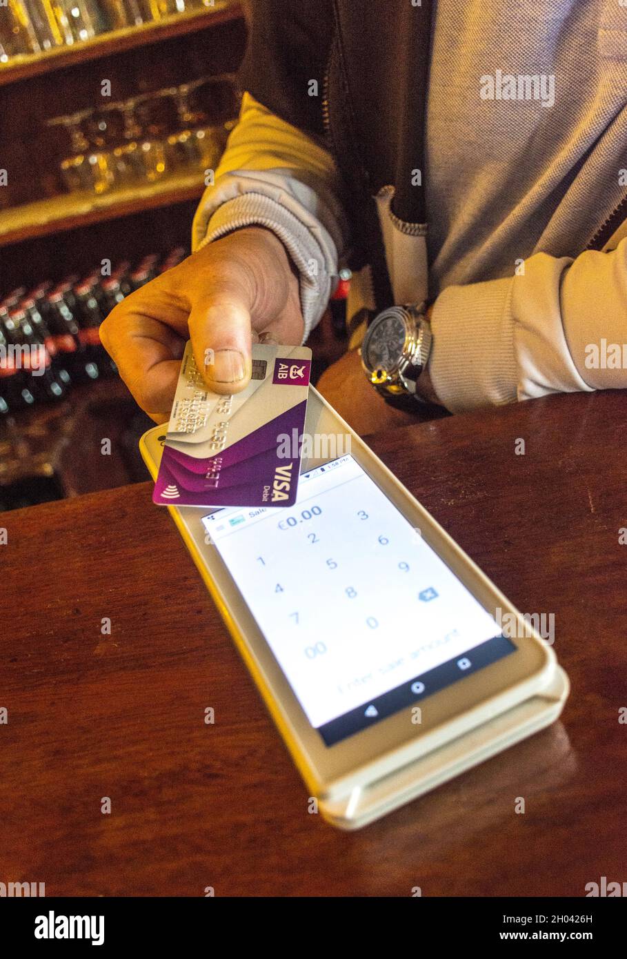 Customer makes a contactless payment with a debit card in a bar in ...