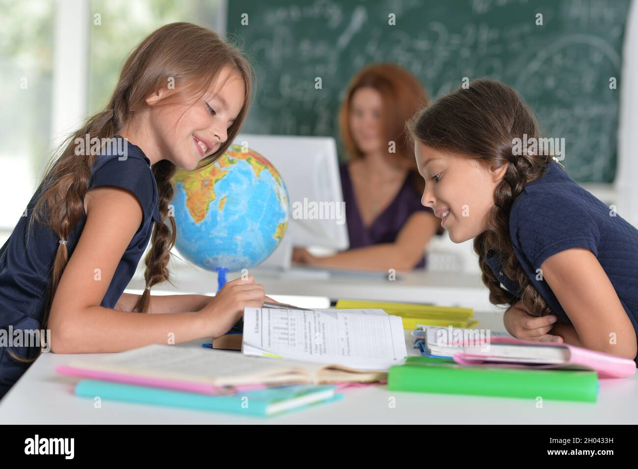 Beautiful girls studying at the desk in class room Stock Photo - Alamy