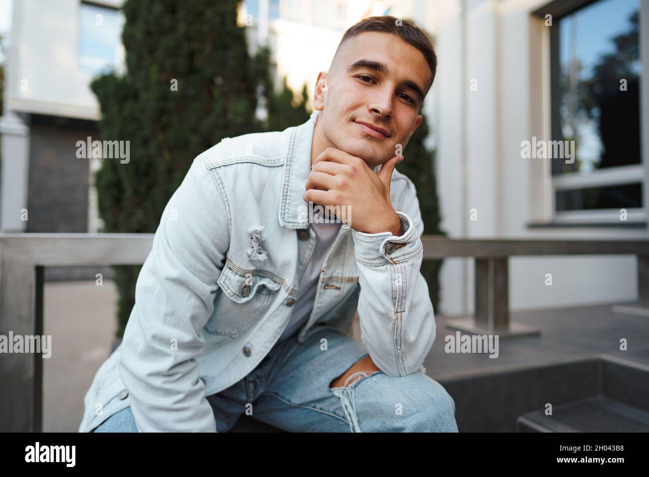 Young casual man sitting on stairs alone on street Stock Photo - Alamy