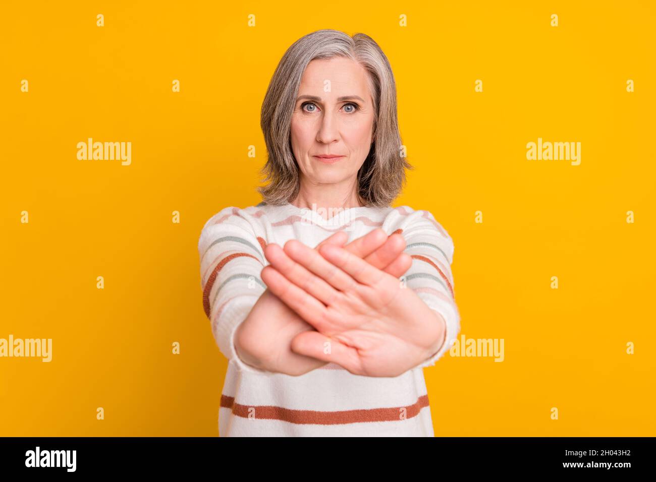 Photo of sad white hairdo aged lady crossed hands wear sweater isolated on yellow color background Stock Photo