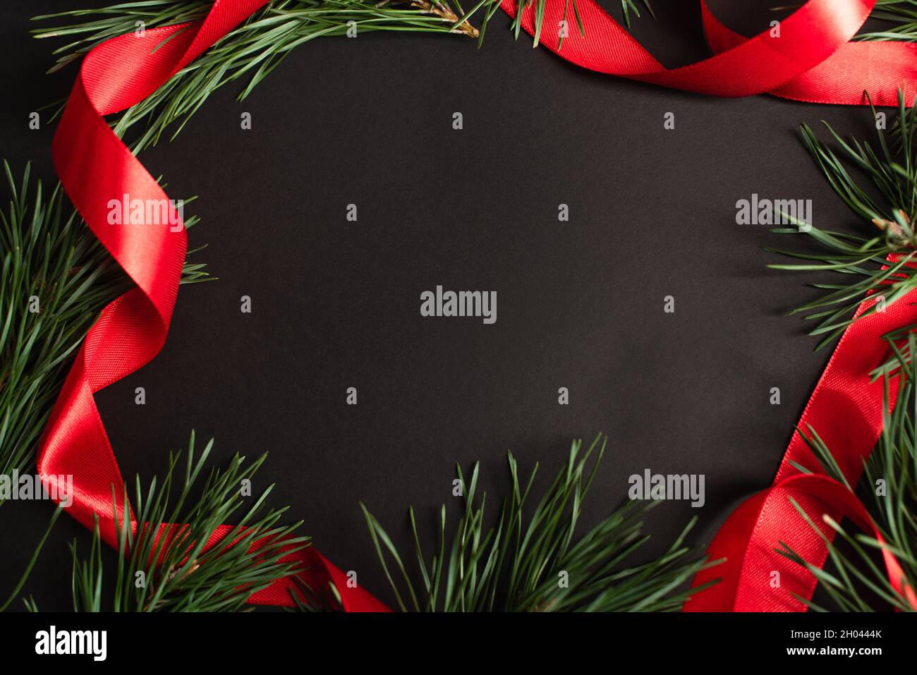 top view of fir branches and red ribbon on black Stock Photo - Alamy