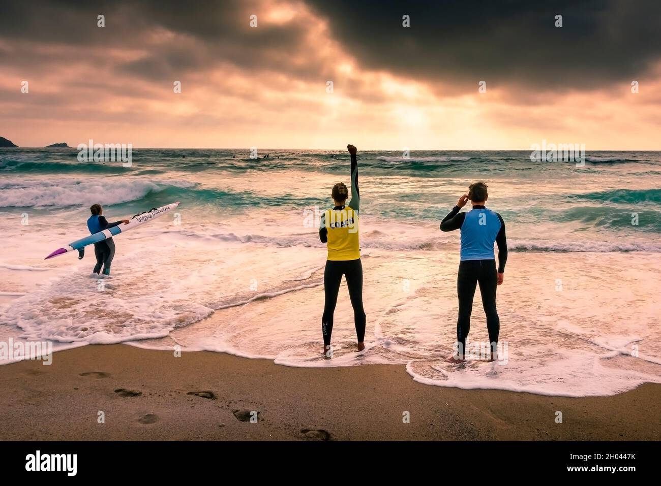 A Coach with members of Newquay Surf Lifesaving Club signalling during a training session on Fistral Beach in Newquay in Cornwall. Stock Photo