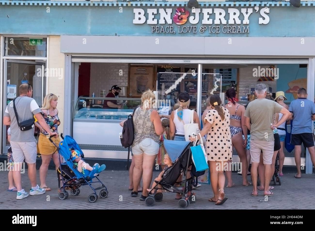 Holidaymakers queueing for ice cream at a Ben & Jerrys shop in Newquay Town centre in Cornwall. Stock Photo