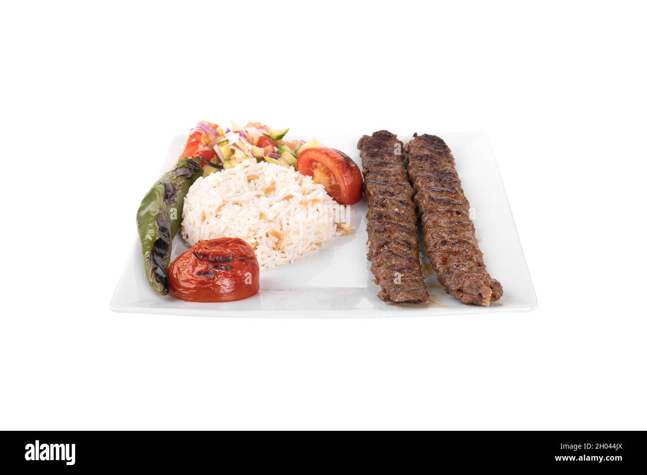 Turkish adana kebab. with vegetables, rice in a porcelain serving plate on white background. adana sis, adana kebap, kiyma kebap Stock Photo