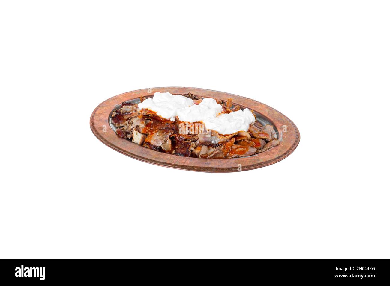 Traditional turkish iskender kebab in copper plate with yogurt. iskender on white background. Stock Photo