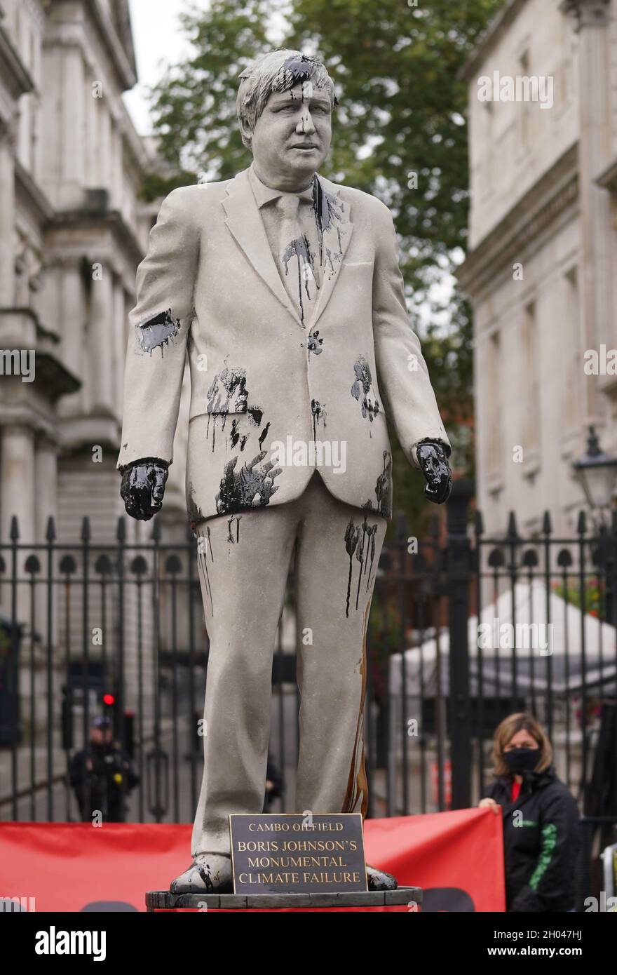 A statue of Prime Minister Boris Johnson splattered with oil as campaigners from Greenpeace demonstrate Downing Street, London, against the Cambo oil field off the west coast of Shetland. Picture date: Monday October 11, 2021. Stock Photo