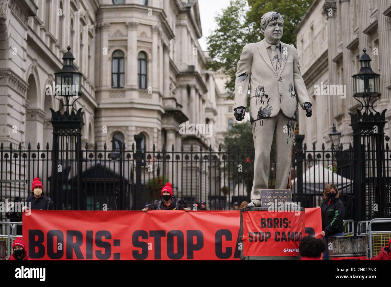A statue of Prime Minister Boris Johnson splattered with oil as campaigners from Greenpeace demonstrate Downing Street, London, against the Cambo oil field off the west coast of Shetland. Picture date: Monday October 11, 2021. Stock Photo