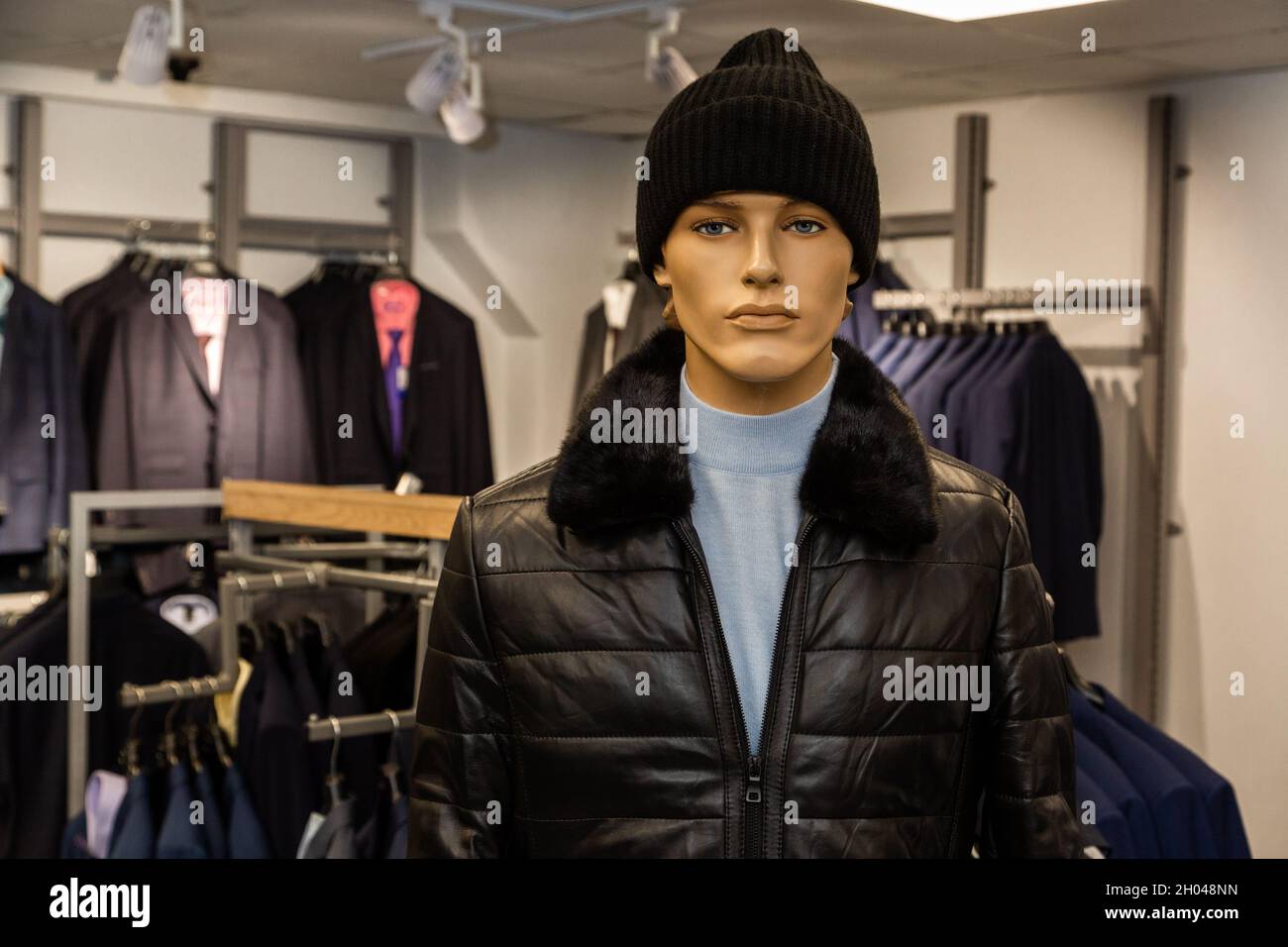 The male mannequin is dressed in fall, winter clothes, a gray turtleneck and a black hat. He is looking at the camera. Stock Photo