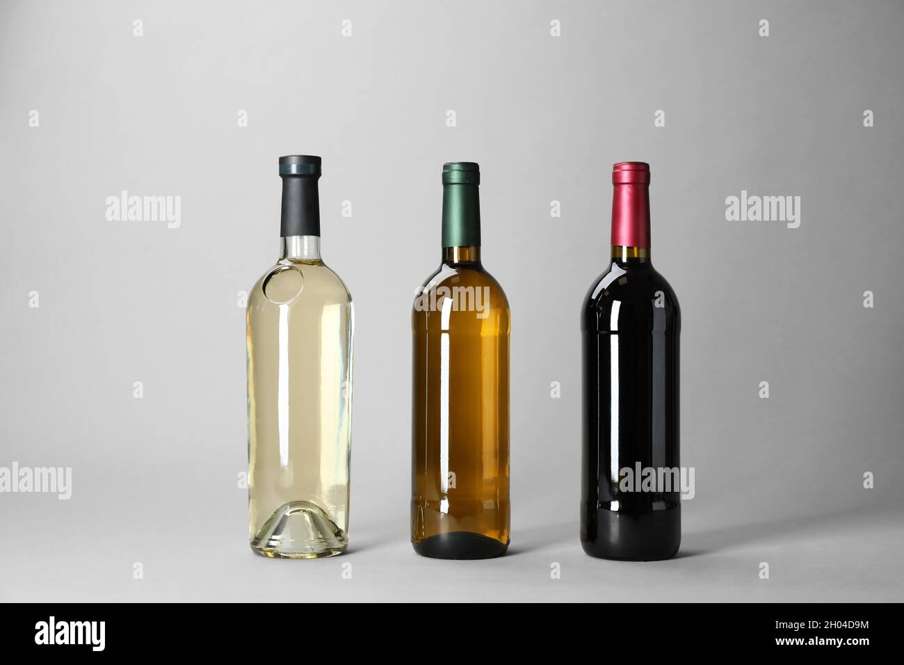 Bottles with different types of wine on light background Stock Photo