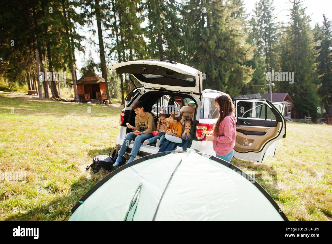 Family of four kids and mother at vehicle interior. Children sitting in ...