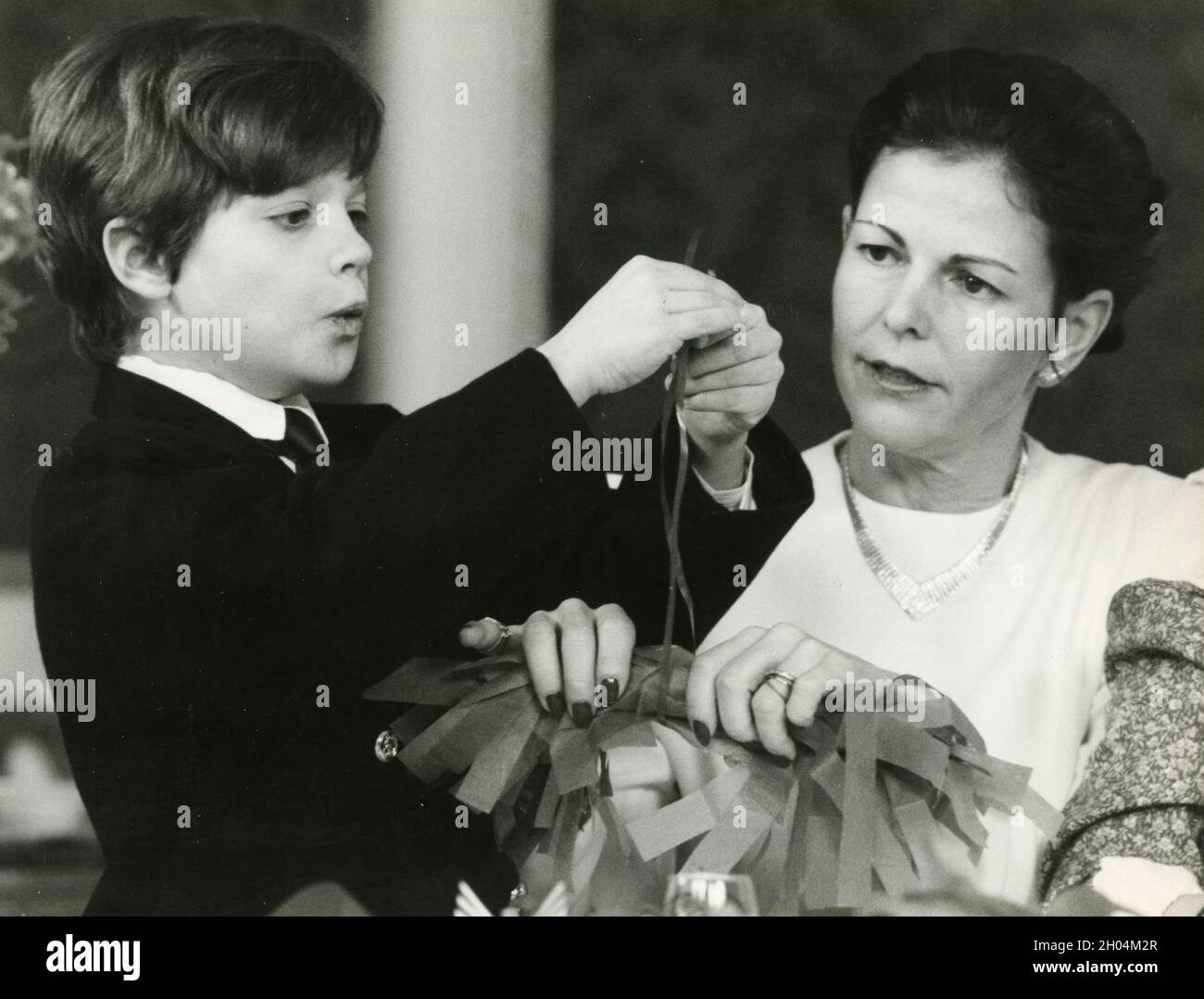 Queen Silvia of Sweden and Prince Carl Philip preparing the Christmas decorations, 1988 Stock Photo