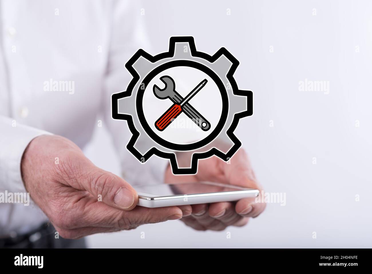 Settings concept above a smartphone held by hands Stock Photo
