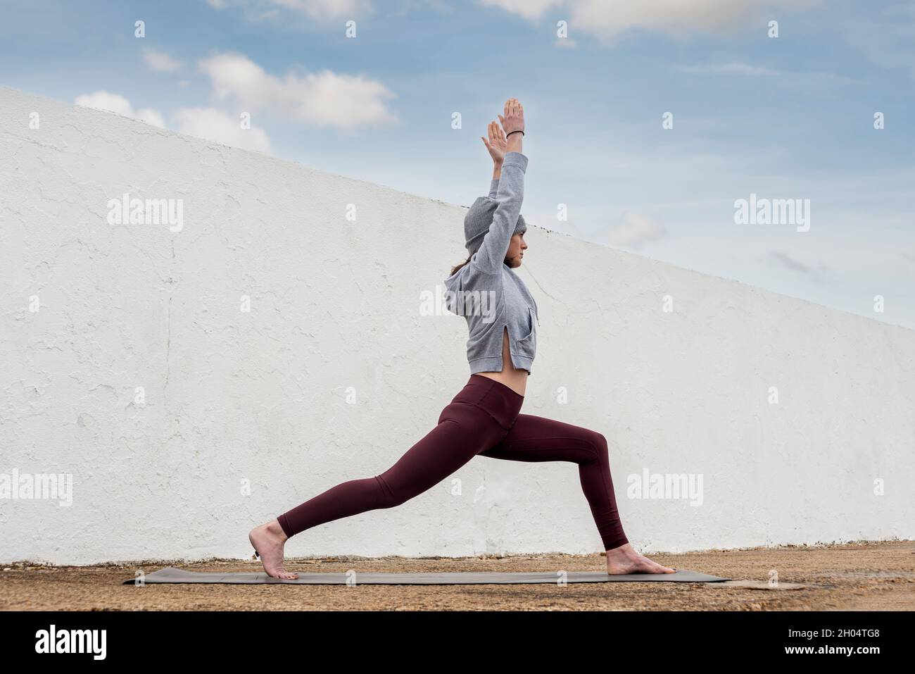 Sporty woman practicing yoga and keeping fit outside in the autumn. Stock Photo