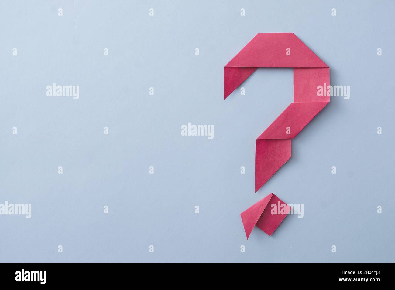 Creative decorative red folded paper origami question mark placed to