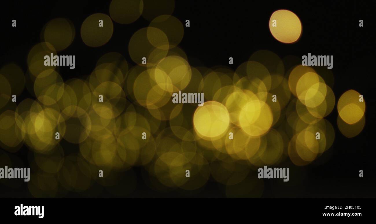 Multiple yellow fairy lights glowing on black background Stock Photo