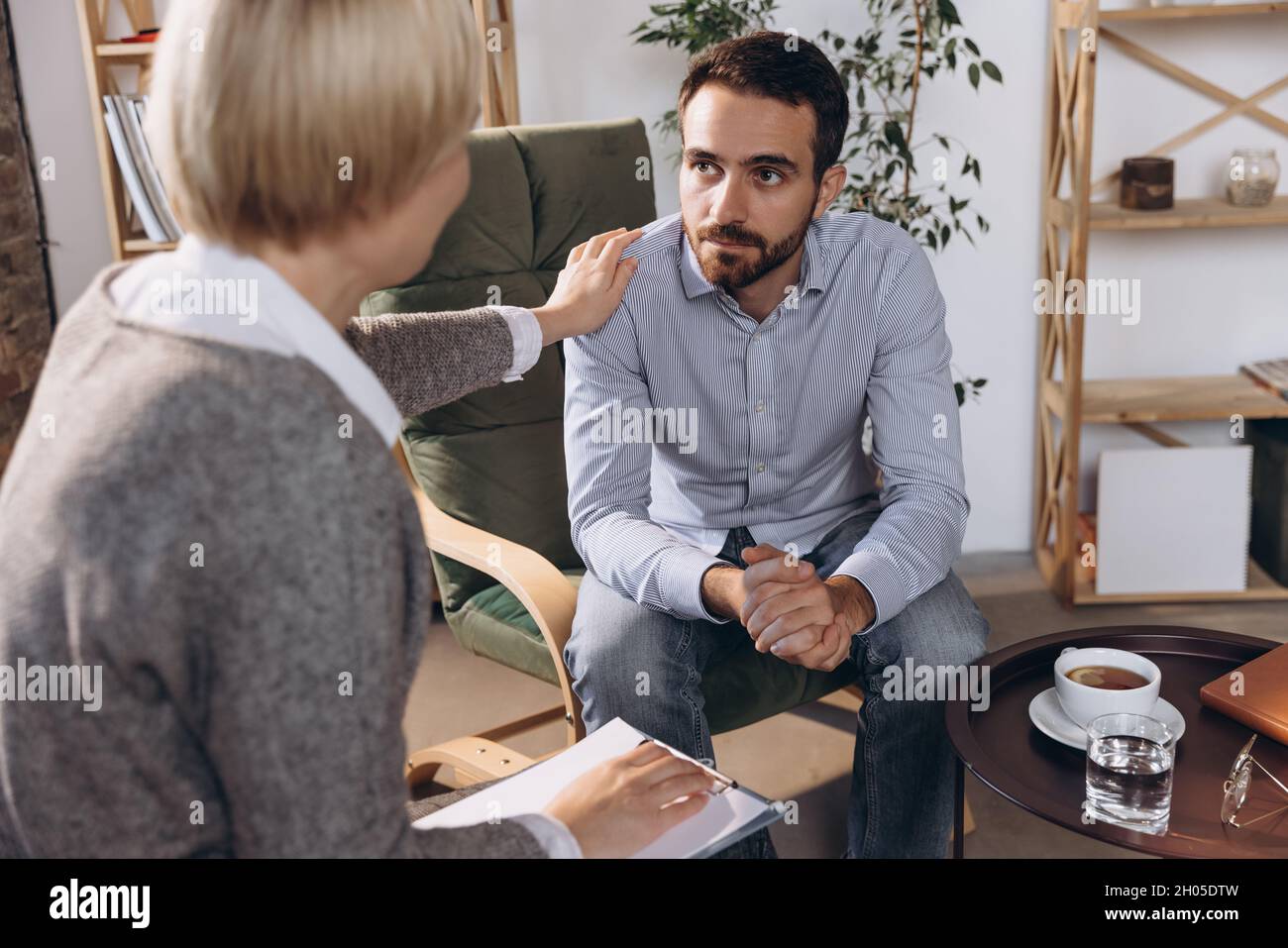 Meeting with psychologist. Young woman, consultant helps sad man cope