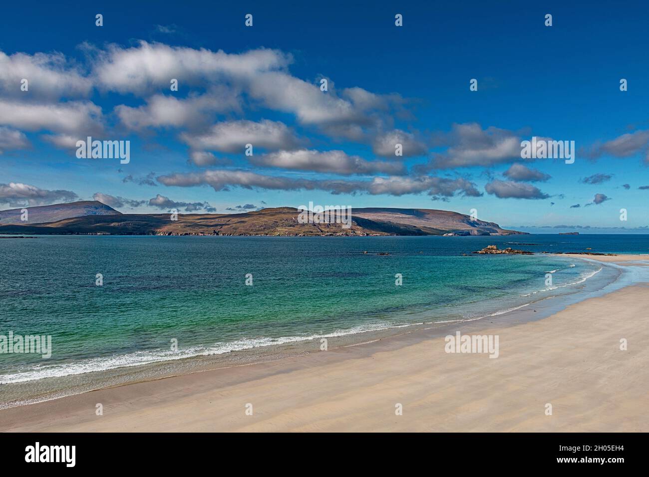 DURNESS SUTHERLAND SCOTLAND A BLUE SKY GEEN BLUE SEA AND SAND COVERED BEACH IN LATE SUMMER Stock Photo