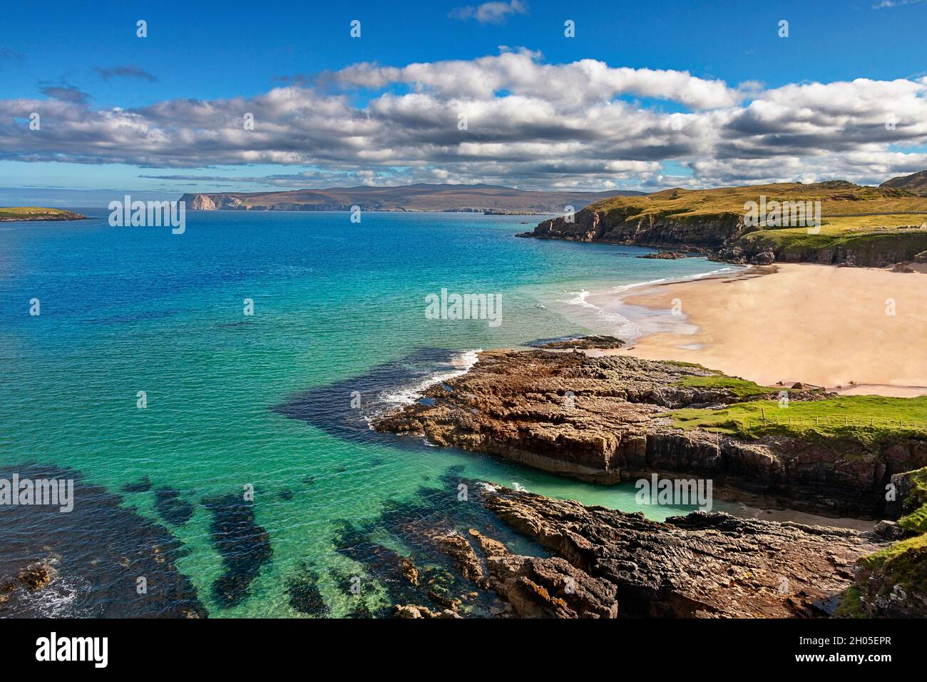 DURNESS SUTHERLAND SCOTLAND A SANDY BEACH ROCKS  A BLUE SKY AND A TURQUOISE SEA IN LATE SUMMER Stock Photo