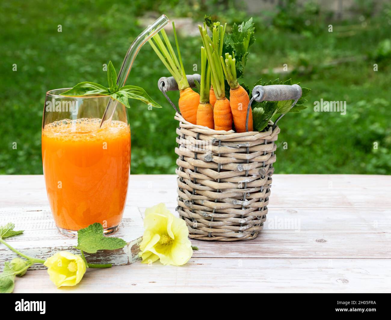 Fresh squeezed carrot juice in a glass on a wooden surface, rustic style Healthy eating, detox, dieting and vegetarian concept. Stock Photo