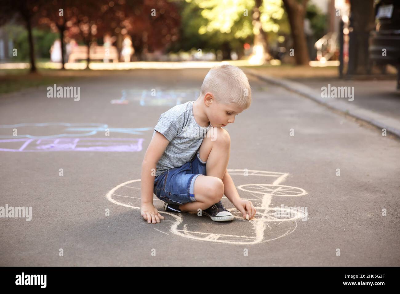 Little child drawing car with chalk on asphalt Stock Photo - Alamy