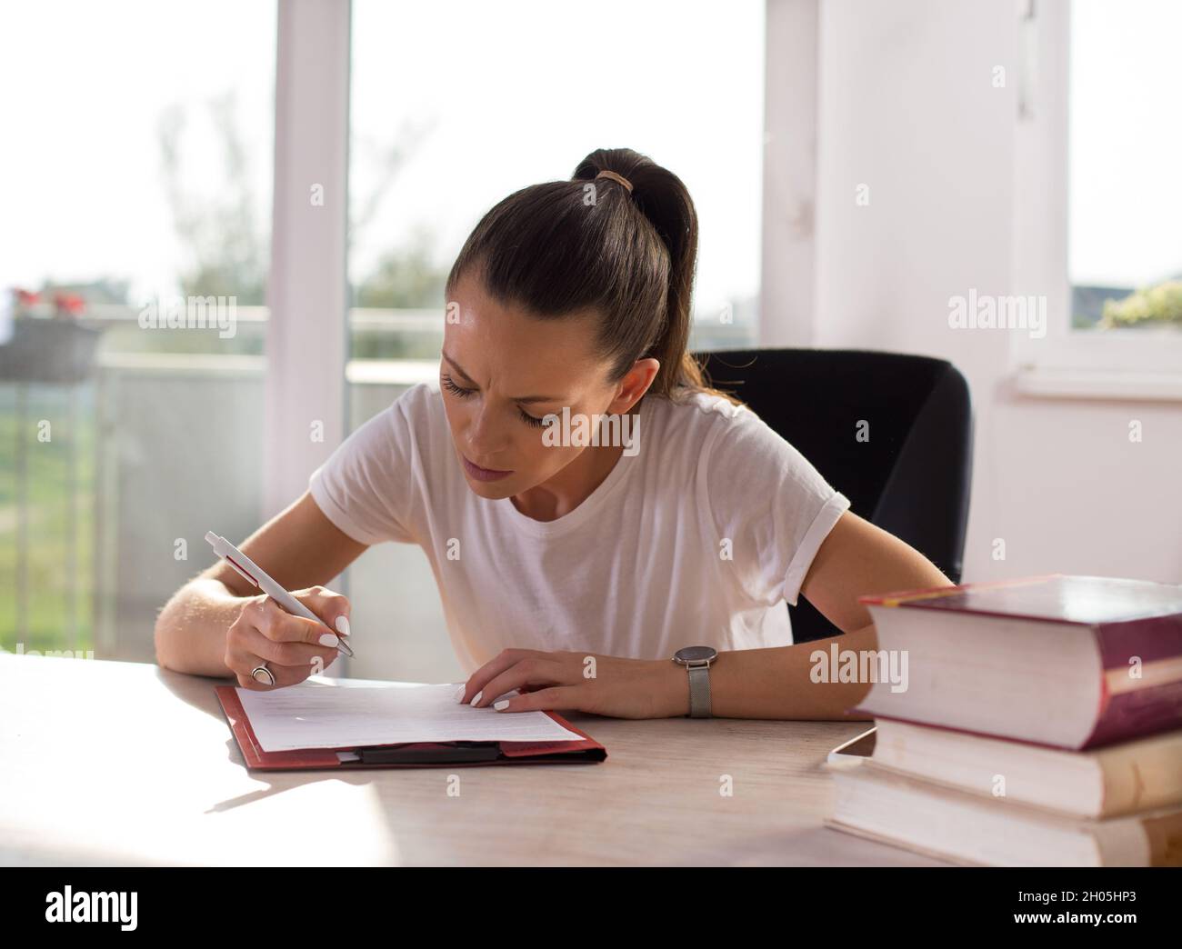 Student girl writing notes at table at home. Education and studying ...