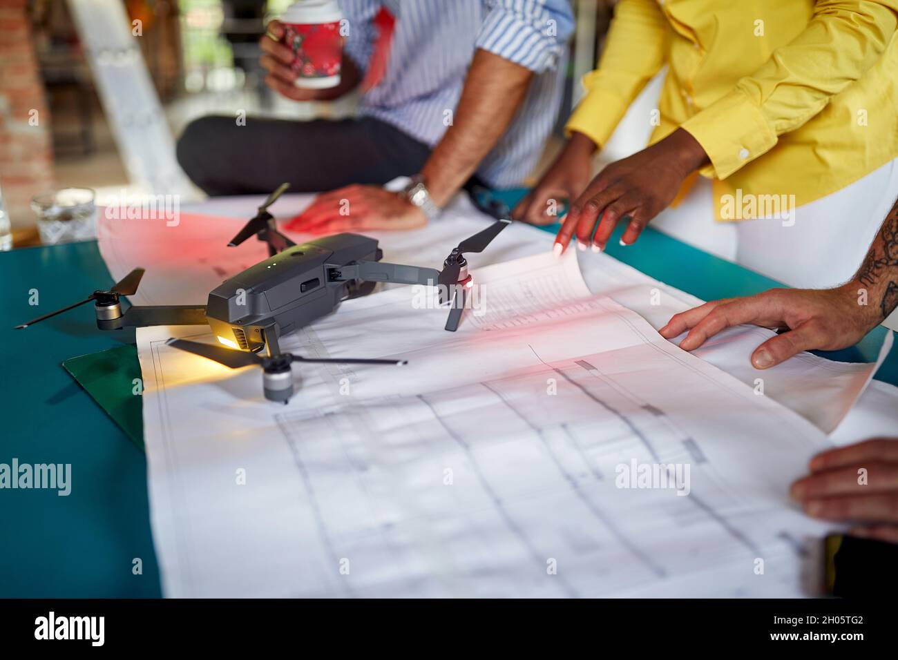 Group of colleagues collaborating on a projecting the drone together ...
