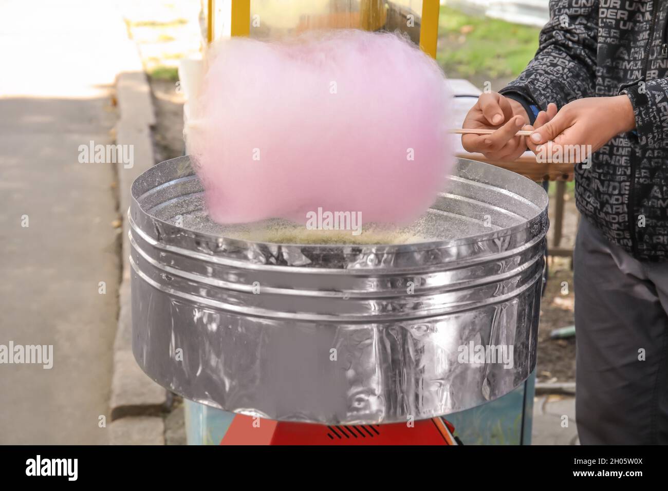 Man making cotton candy in floss machine outdoors Stock Photo - Alamy
