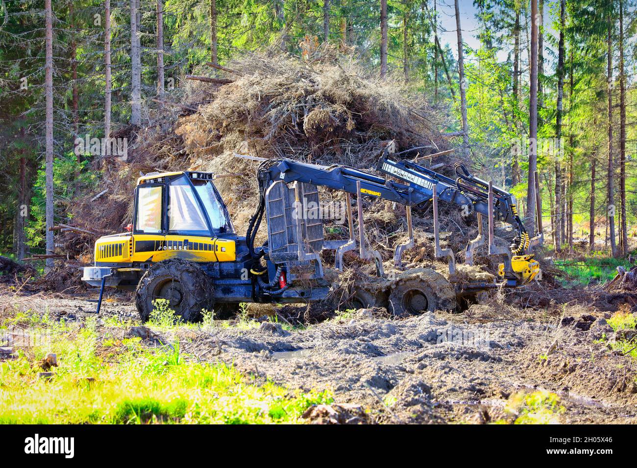 Ponsse Elk compact forest forwarder on wet forest logging site in early autumn next to a heap of brushwood. Koski Tl, Finland. August 7, 2020. Stock Photo
