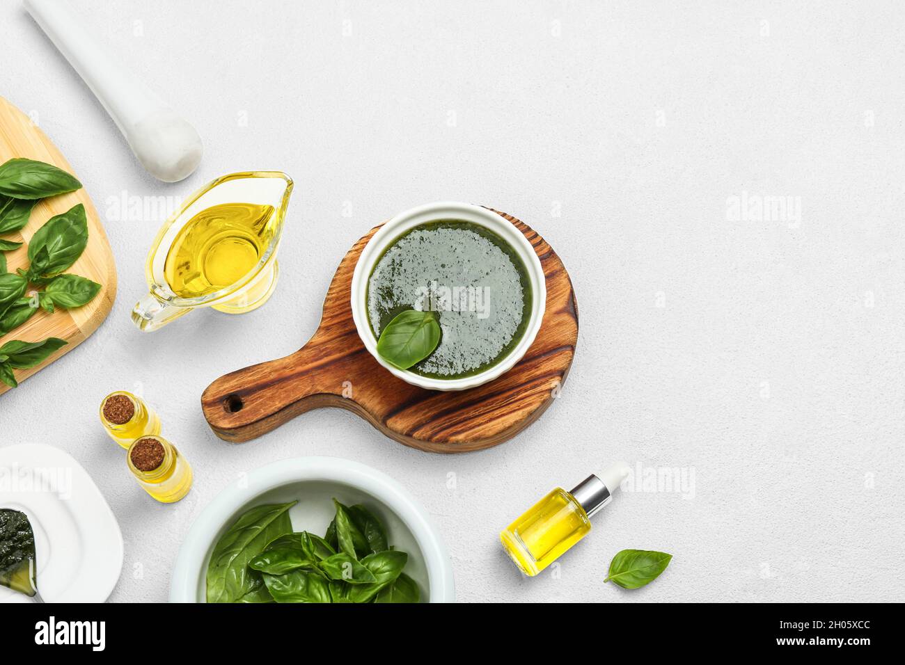 Composition with basil oil and leaves on white table. Space for text ...