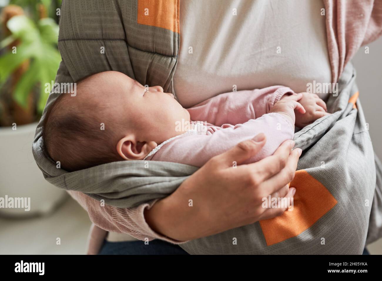 Closeup of cute baby girl sleeping while her mother holding her on