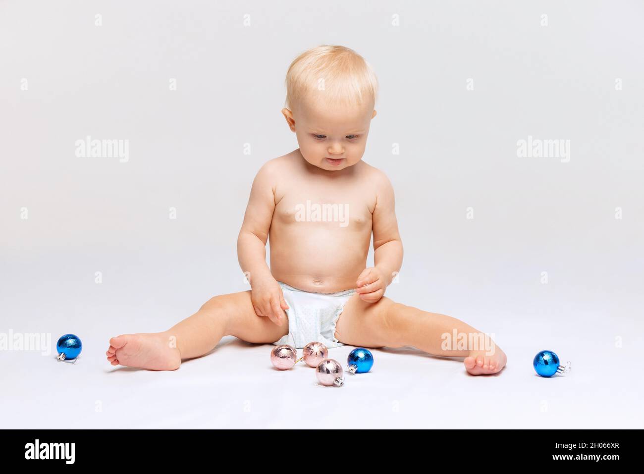 Fulllength portrait of little cute toddler girl, baby calmly sitting