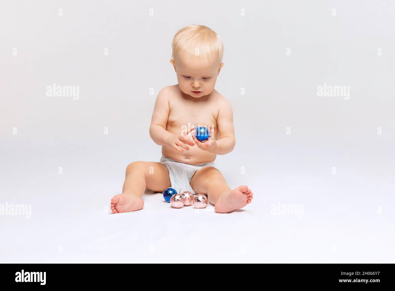 Fulllength portrait of little cute toddler girl, baby calmly sitting