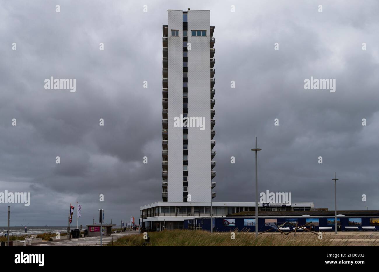 The photo shows a skyscraper on the beach of Zandvoort in the Netherlands with dramatic cloudy sky Stock Photo