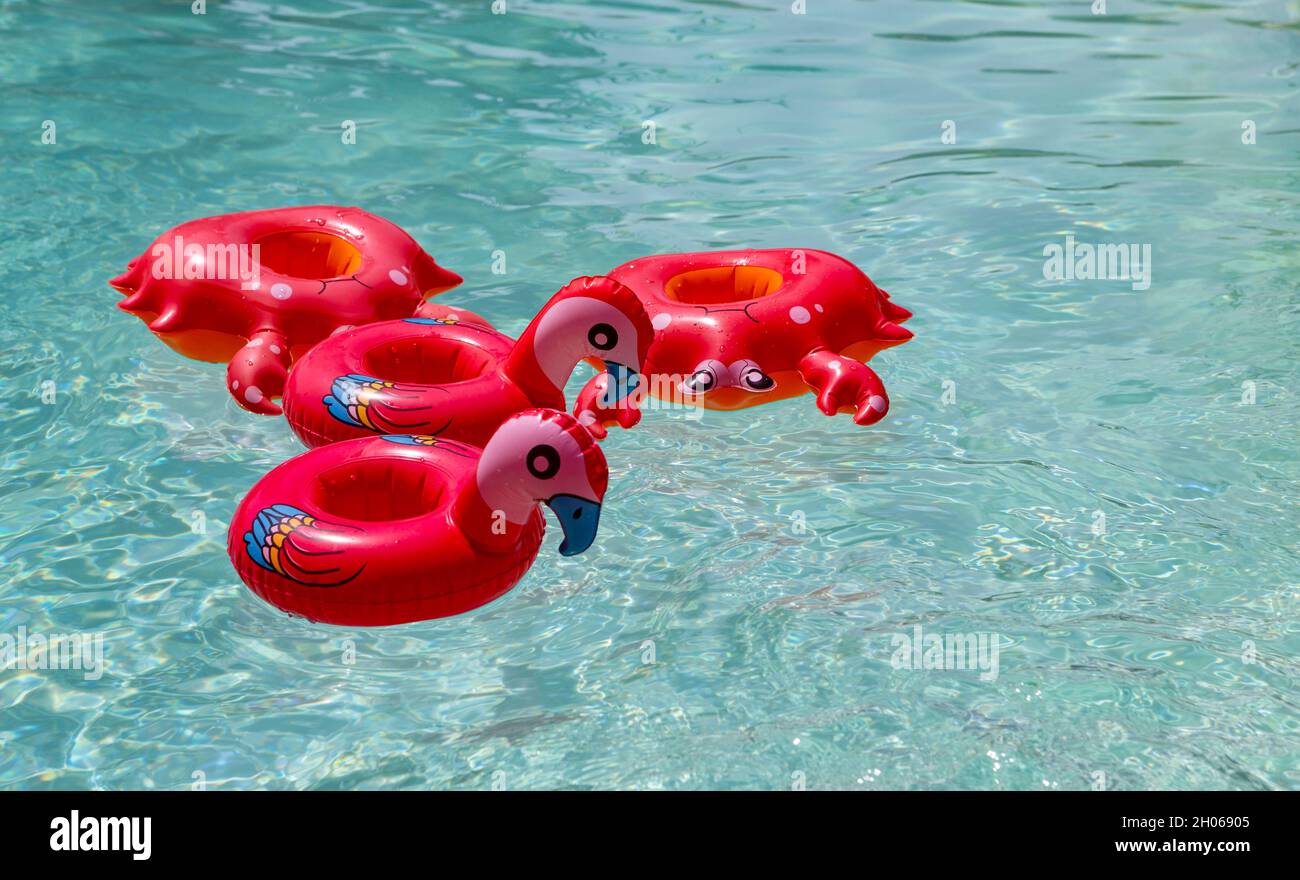 The photo shows different, inflated, cup holders in a pool Stock Photo
