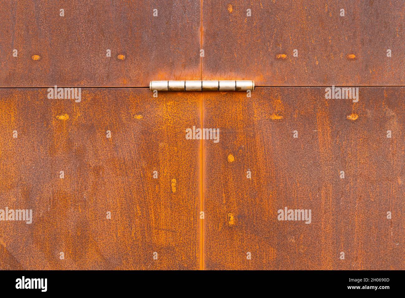 The photo shows a weathered and rusty metal door Stock Photo
