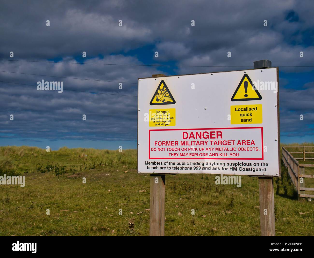 A large sign next to a former military target area warns not to pick up any metallic objects or military debris, which may prove fatal. The sign also Stock Photo
