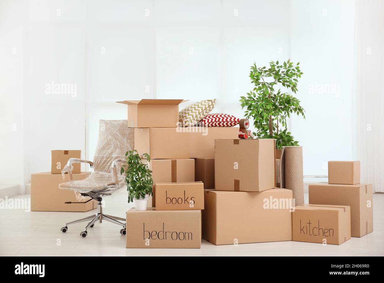 Pile of moving boxes in empty room Stock Photo - Alamy