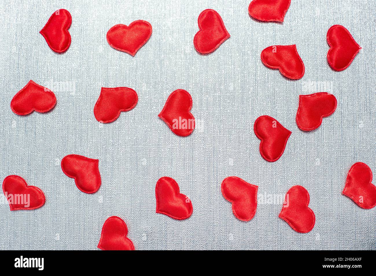 red hearts scattered on a silver background Stock Photo
