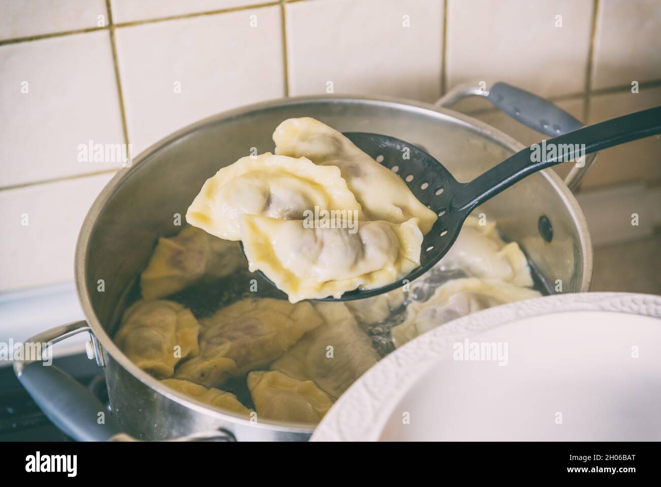Cooking fresh dumplings filled with sour cherry with sugar Stock Photo