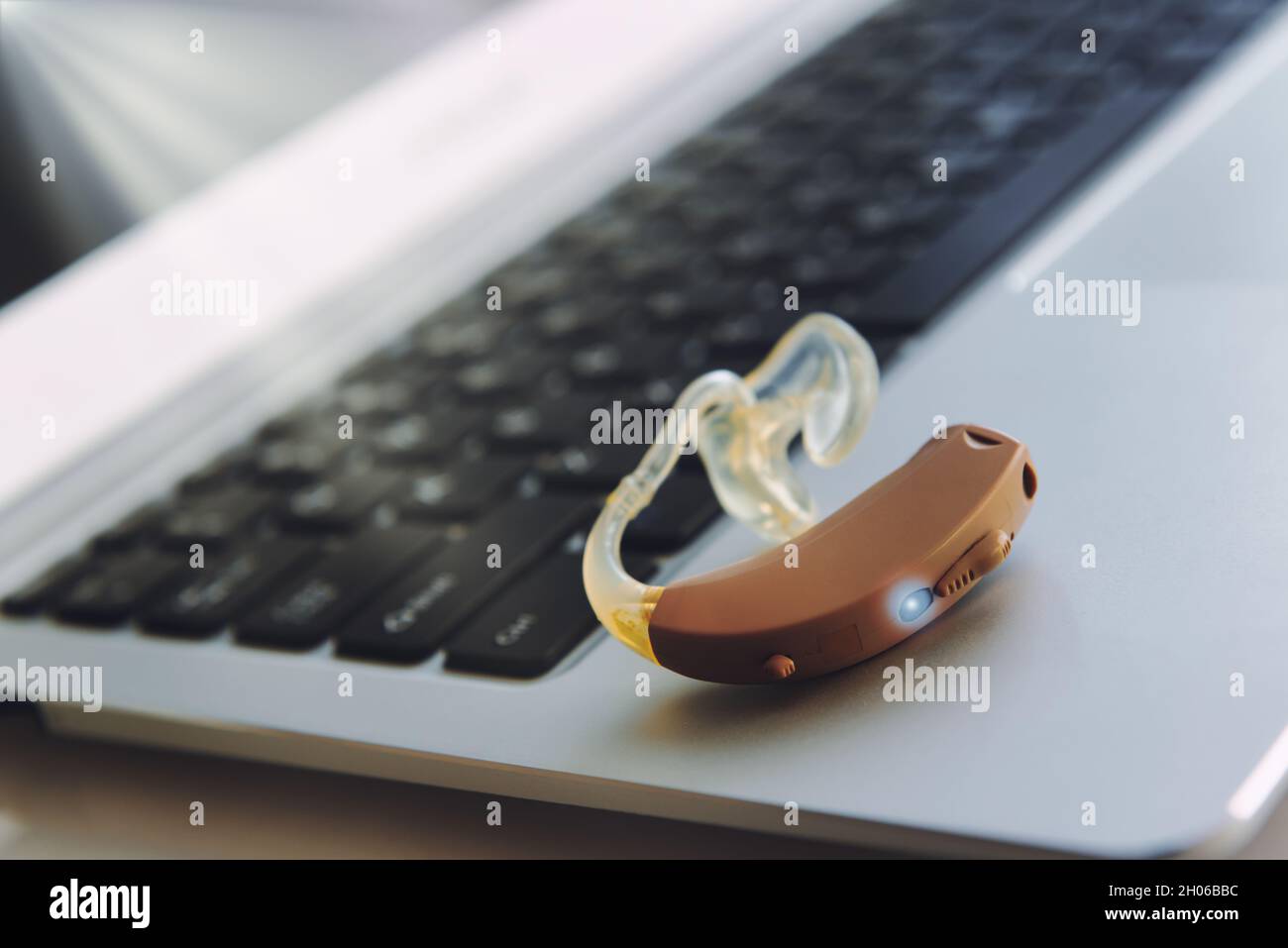 Hearing aid device on laptop, work in office for deaf people Stock Photo