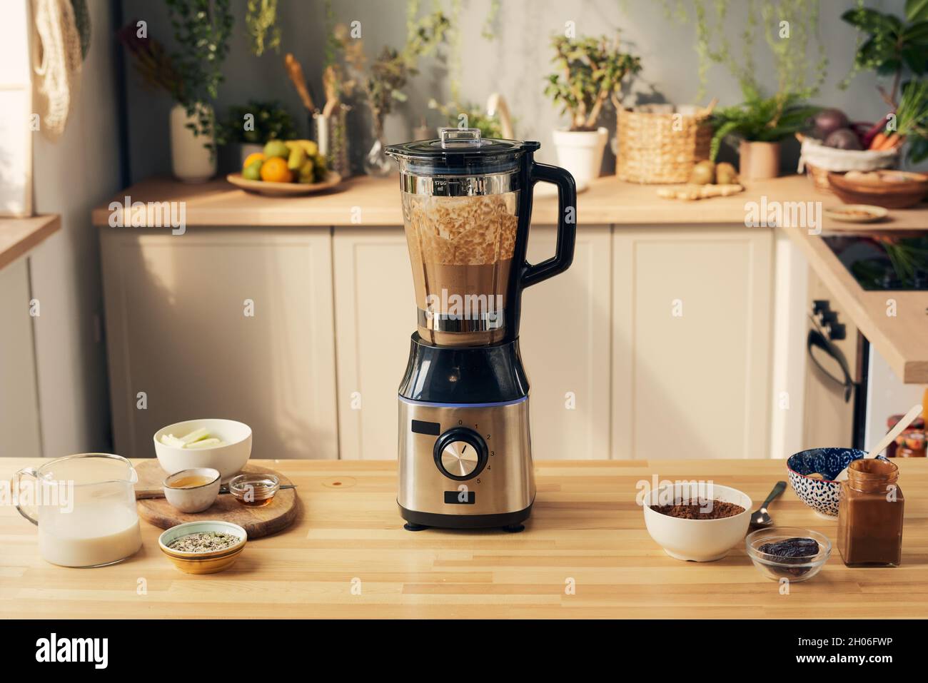 https://c8.alamy.com/comp/2H06FWP/kitchen-table-with-electric-blender-with-chocolate-smoothie-and-bowls-with-ingredients-2H06FWP.jpg