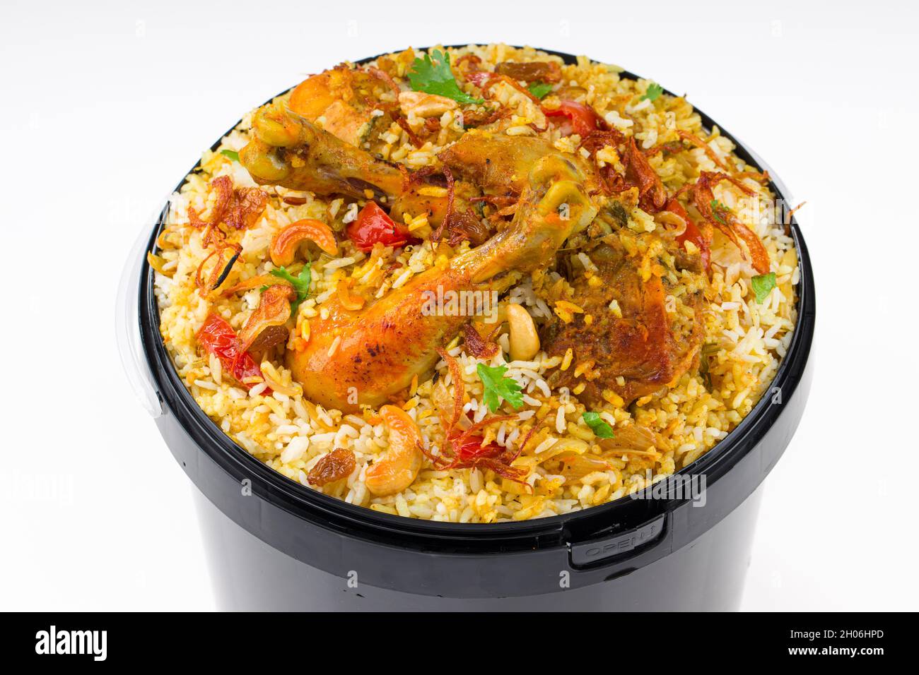 Chicken Bucket Biryani, Kerala dum chicken biryani arranged in a black bucket container with white textured background. Stock Photo