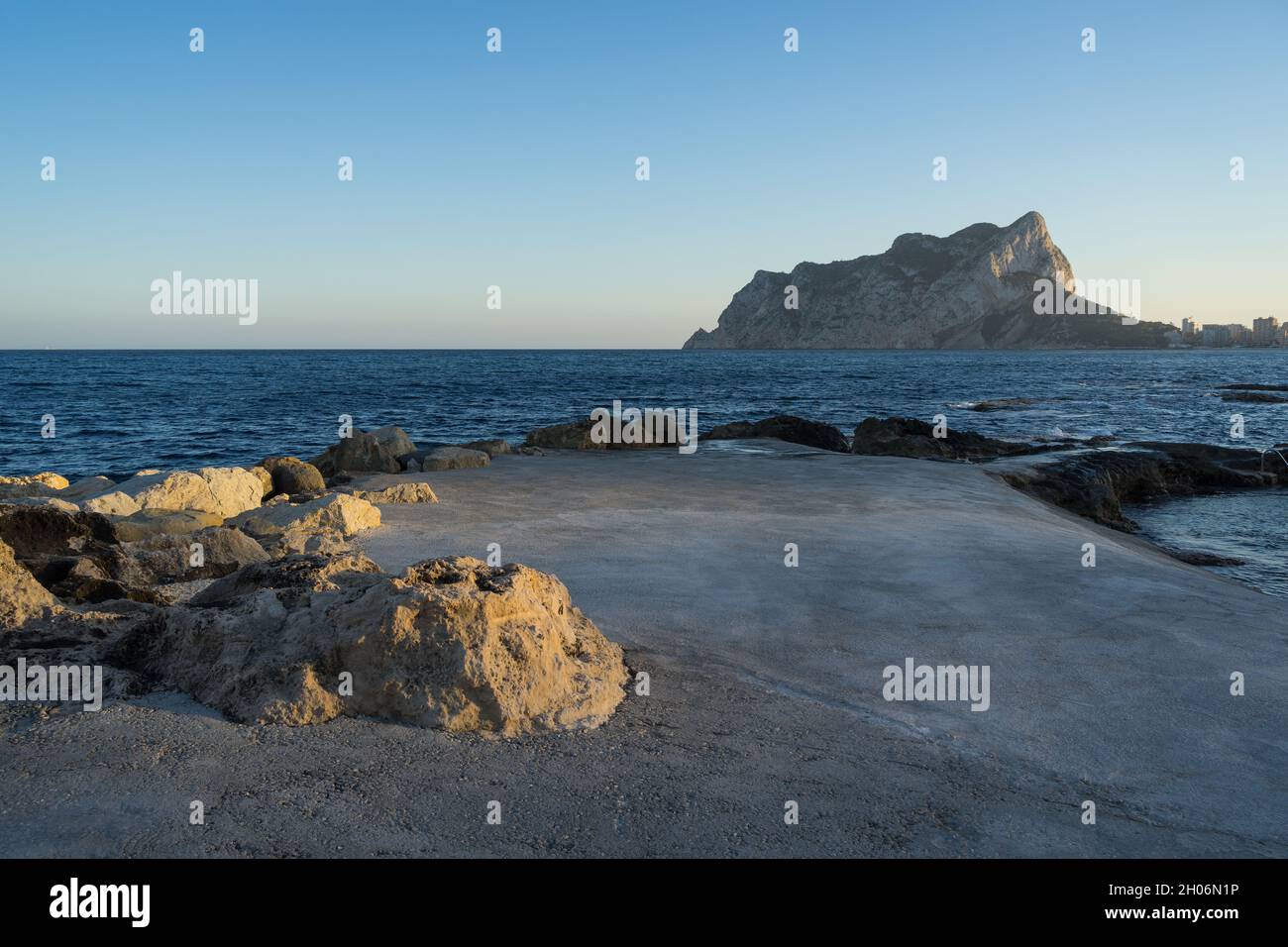 blue Mediterranean sea and rocks at sunset in Calpe view of the Peñón de Ifach travel destination Costa Blanca Stock Photo