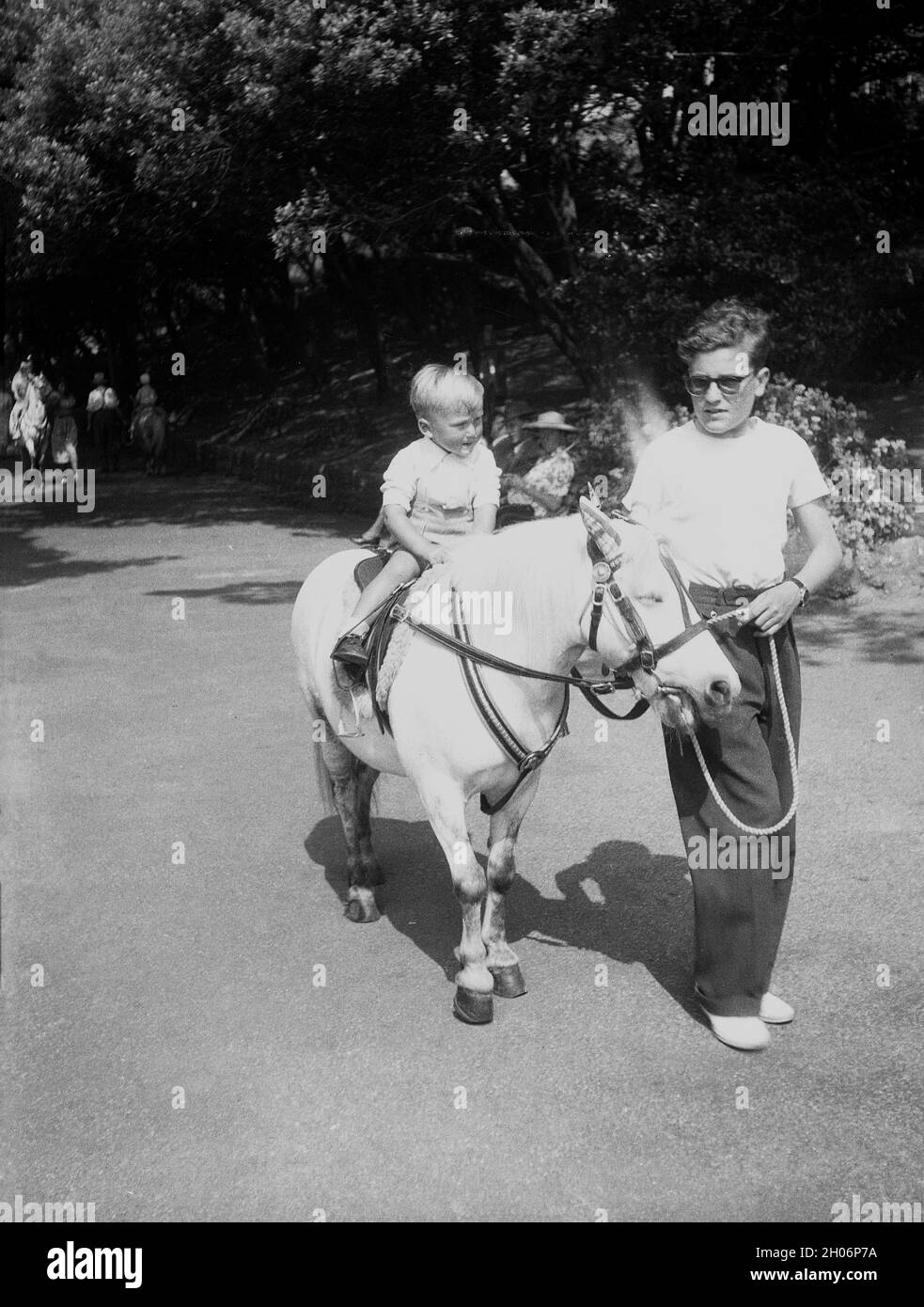 1950s, historical, summertime and a little boy having a pony ride, England, UK. Stock Photo