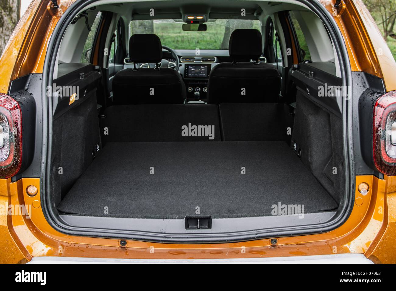 Huge, clean and empty car trunk of a modern compact suv. Rear view of a SUV car with open trunk and folded passenger seats. Stock Photo