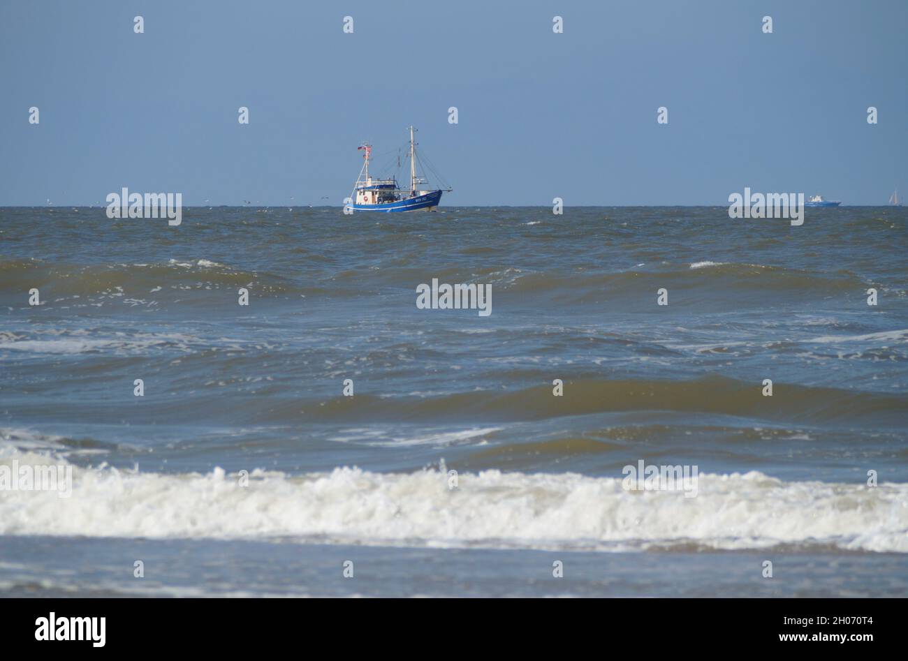 A blue fishing cutter in the North Sea in Germany Stock Photo