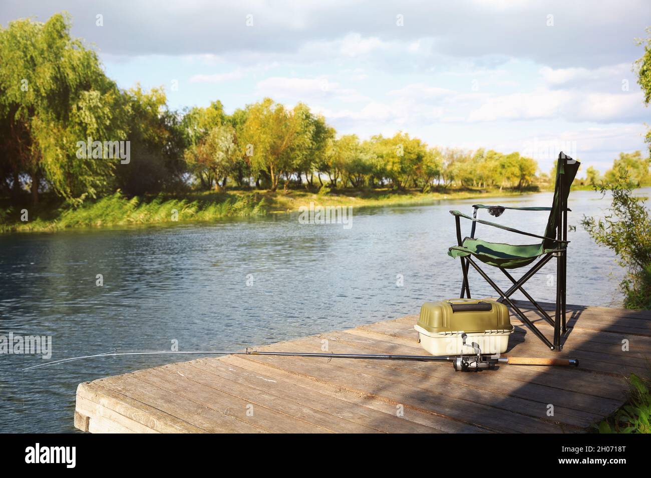 https://c8.alamy.com/comp/2H0718T/folding-chair-tackle-box-and-rod-for-fishing-on-wooden-pier-at-riverside-recreational-activity-2H0718T.jpg