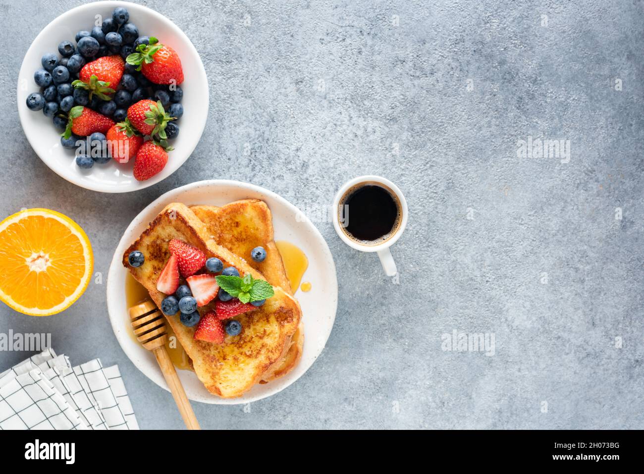 Sweet french toast with berries and cup of coffee on concrete background. Top view, copy space. Breakfast or sweet brunch food Stock Photo
